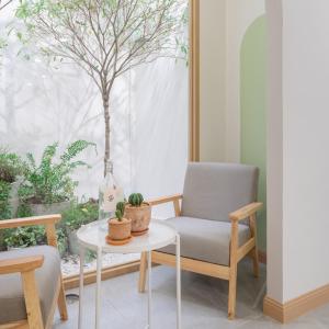 a chair and a table in a room with a tree at COROOM BKK in Bangkok