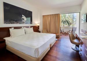 a bedroom with a large bed and a large window at Hotel Porto Santo & Spa in Porto Santo