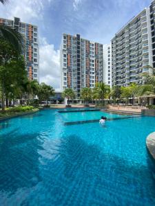a large pool with blue water in front of tall buildings at The Jomvacay Place in Kuantan