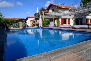 una piscina de agua azul frente a una casa en The Secret Spot Lodge, en Azur