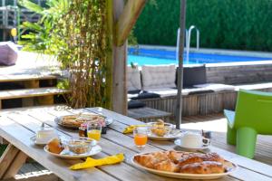 una mesa de madera con platos de comida encima en The Secret Spot Lodge, en Azur