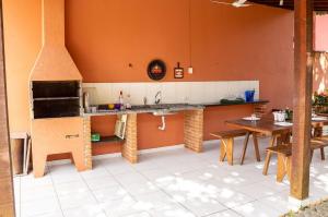 a kitchen with a counter and a table and a stove at Casa com piscina a 350m da praia em Boiçucanga in Boicucanga +41 photos