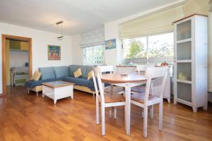 a living room with a table and a blue couch at Bonito apartamento en la playa in Benicàssim