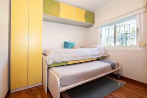 a small bedroom with a bed and a window at Bonito apartamento en la playa in Benicàssim
