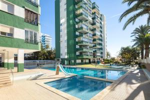 a swimming pool in front of a tall apartment building at Bonito apartamento en la playa in Benicàssim