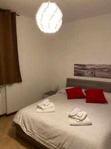 een slaapkamer met een bed met twee handdoeken erop bij “Coccole nel borgo” 2min to outlet in Serravalle Scrivia