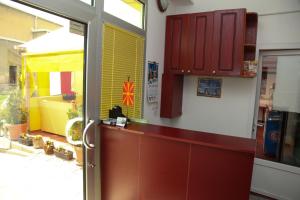 a kitchen with red cabinets and a sliding glass door at DJ Apartments Plus in Ohrid