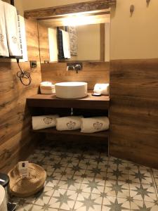 a bathroom with a sink and a mirror and towels at Hotel Boutique Casa del Comendador in Navalcarnero