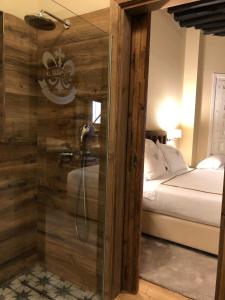 una ducha con puerta de cristal en un dormitorio en Hotel Boutique Casa del Comendador en Navalcarnero