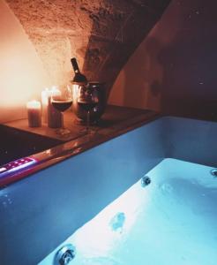una vasca da bagno con 2 bicchieri di vino e candele di Mastropaolo42 Luxury B&B a Grottaglie