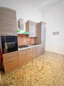 uma cozinha com armários de madeira e um piso estampado em La Casa del Borgo em Lecce