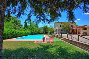 a swimming pool in a yard with a house at Zeffiro by PosarelliVillas in Cortona