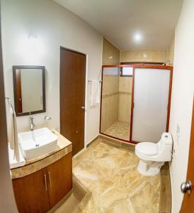 a bathroom with a toilet and a sink and a shower at Villas Najo' Isla Mujeres. in Isla Mujeres
