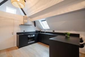 eine Küche mit schwarzen Schränken und einer schwarzen Arbeitsplatte in der Unterkunft Smartflats - Grand-Place II in Brüssel