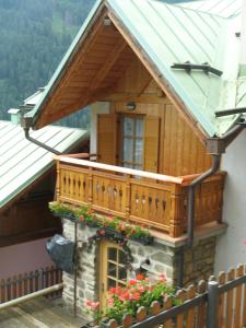 a house with a balcony with flowers on it at B&B Mary in Peio