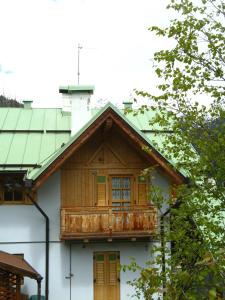 a house with a wooden balcony on top of it at B&B Mary in Peio