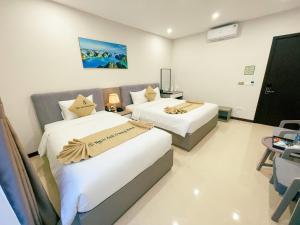 two beds in a hotel room with at Ngọc Ánh Dương Hotel in Ha Long