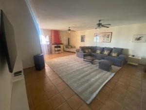 a living room with a blue couch and a rug at Villa Tranquilla in Estepona