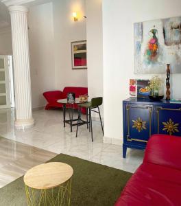 ein Wohnzimmer mit einem roten Sofa und einem Tisch in der Unterkunft Francesca Guest House in Dakar