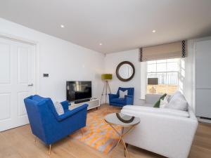 a living room with a white couch and blue chairs at Pass The Keys Quiet 1 bed central apartment with parking in Bath