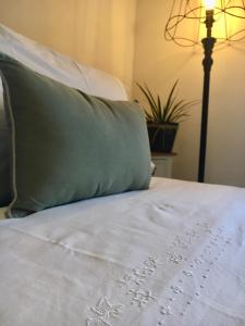a bed with a green pillow on top of it at Vento d’Orcia in Pienza