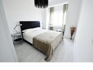 Dormitorio blanco con cama y mesa en NiM Sagrada Familia 2, en Barcelona