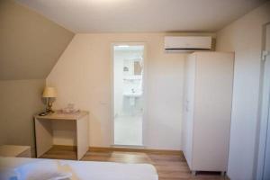 Schlafzimmer mit einem Bett, einem Schreibtisch und einem Fenster in der Unterkunft Pensiune Xe-Mar in Arad