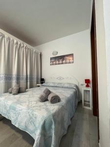a bed in a bedroom with a white bedspread at Studio's Pavese in Olbia