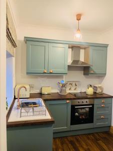 貝林翰的住宿－5 The Croft，厨房配有蓝色橱柜和台面