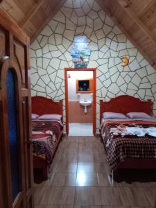 baño con 2 camas y lavabo en una habitación en Cabañas camino real, en Santiago