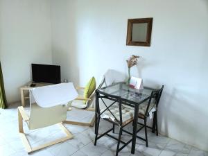 a living room with a glass table and chairs at Bay View Studio Apartment 3B - Canouan Island in Canouan