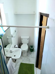 a white bathroom with a toilet and a sink at Bay View Studio Apartment 3B - Canouan Island in Canouan