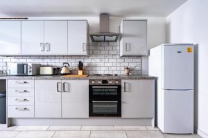 a kitchen with white cabinets and a refrigerator at Dalhousie Lower in Glasgow