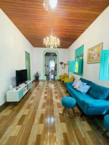 a living room with a blue couch and a tv at Casa com Piscina in Canavieiras