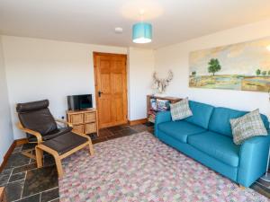 sala de estar con sofá azul y silla en Blackburn Cottage Barn, en Hamsterley