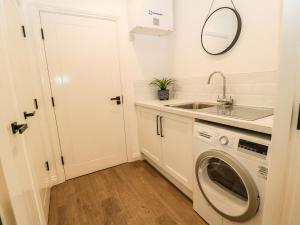 a small kitchen with a washing machine and a sink at Over The Arch in Keighley