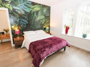 a bedroom with a large bed with a painting on the wall at Over The Arch in Keighley