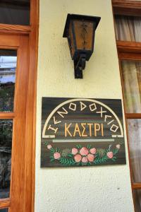 um sinal na lateral de um edifício com uma luz em Castri Hotel em Delphi