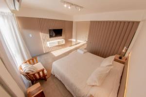 Habitación de hotel con cama y silla en Decom Suites en La Rioja