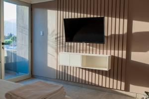 a living room with a television on a wall at Decom Suites in La Rioja
