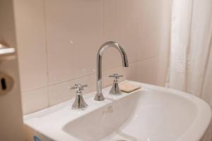 a white sink with a faucet in a bathroom at Decom Suites in La Rioja