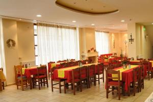 a restaurant with red and yellow tables and chairs at Castri Hotel in Delfoi