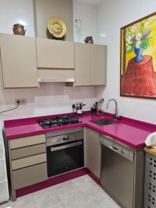 uma cozinha com uma bancada rosa e um lavatório em LOS BALCONES DE LA CALLE CAÑON em Cartagena
