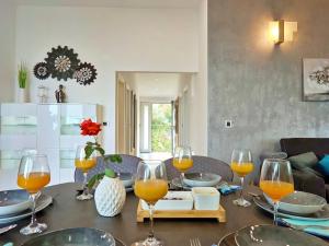a dining room table with wine glasses on it at Luxury Sunrise Jacuzzi Apts, 50 m from the beach in Kali