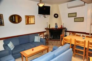 een woonkamer met blauwe banken en een open haard bij Castri Hotel in Delfoi