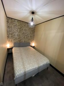 a bedroom with a bed and two lights on the wall at Appartement chic et cosy au pied du village in Villard-de-Lans