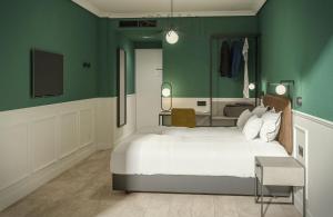 パレンシアにあるホテル ドン ロドリゴの緑の壁のベッドルーム1室(ベッド2台付)