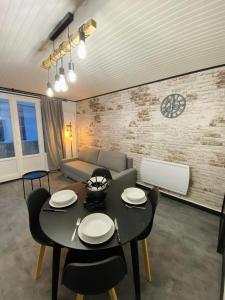 uma sala de estar com uma mesa preta e cadeiras em Appartement chic et cosy au pied du village em Villard-de-Lans