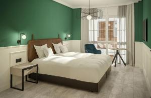 um quarto com uma cama grande e uma parede verde em Hotel Don Rodrigo em Palencia