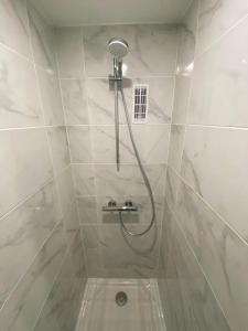 a shower in a white tiled bathroom at Appartement chic et cosy au pied du village in Villard-de-Lans